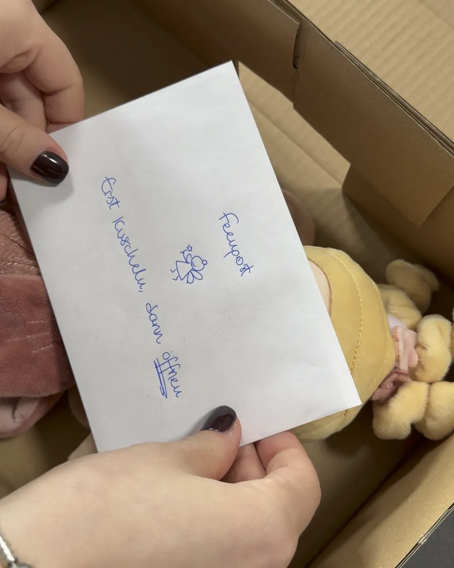 Hände halten den Umschlag über dem Produkt im Karton