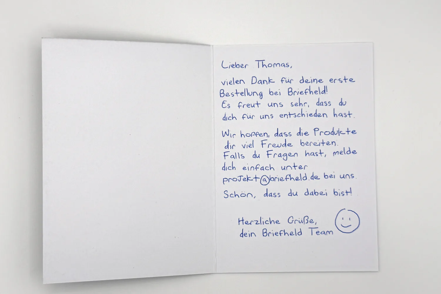 Aufgeklappte Karte: Lieber Thomas, vielen Dank für deine erste Bestellung, handgeschrieben mit Smiley