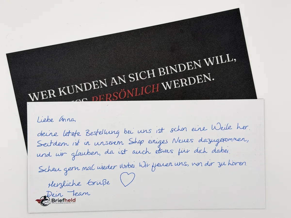 Handgeschriebene Karte „Liebe Anna, deine letzte Bestellung bei uns ist schon eine Weile her“ vor einer dunklen Vorderseite